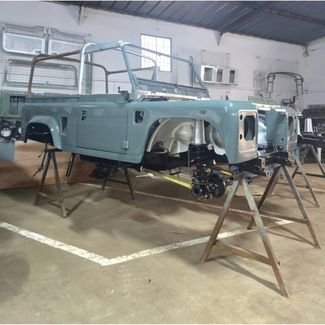 Caisse de Land Rover Defender en cours de restauration sur chandelles en atelier