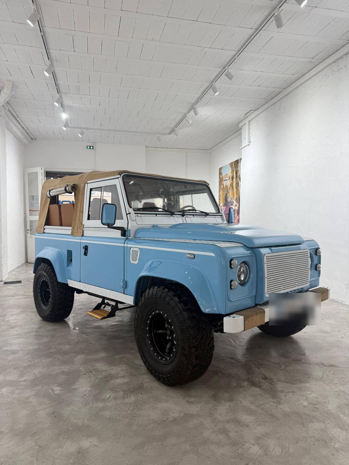 Defender bleu clair restauré, trois quarts avant en showroom