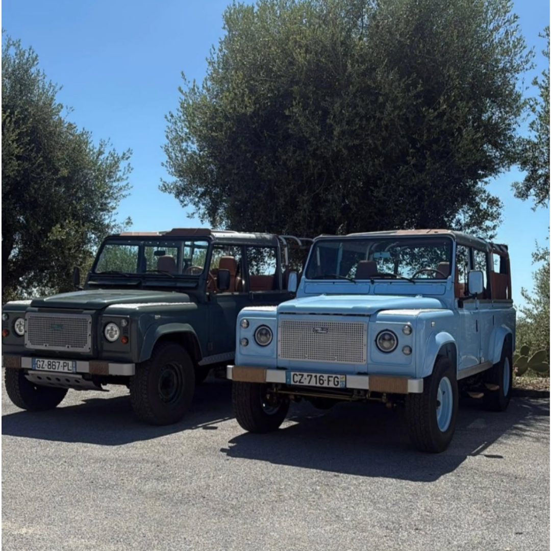 Deux Land Rover Defender restaurés, un vert et un bleu, côte à côte