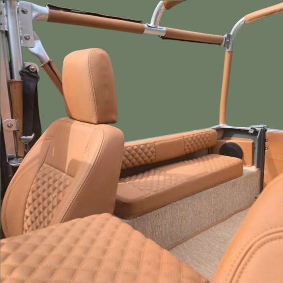 Intérieur Classic Defender — sièges baquets et banquette cuir cognac matelassé