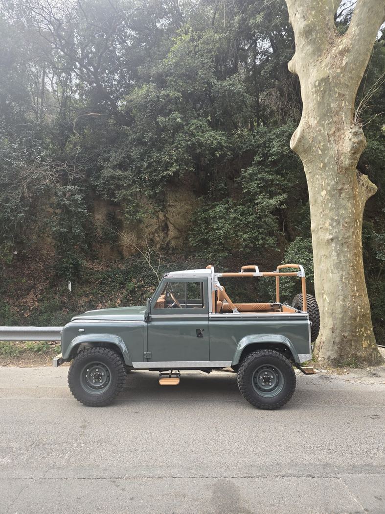 Defender kaki restauré, profil sur une route de campagne