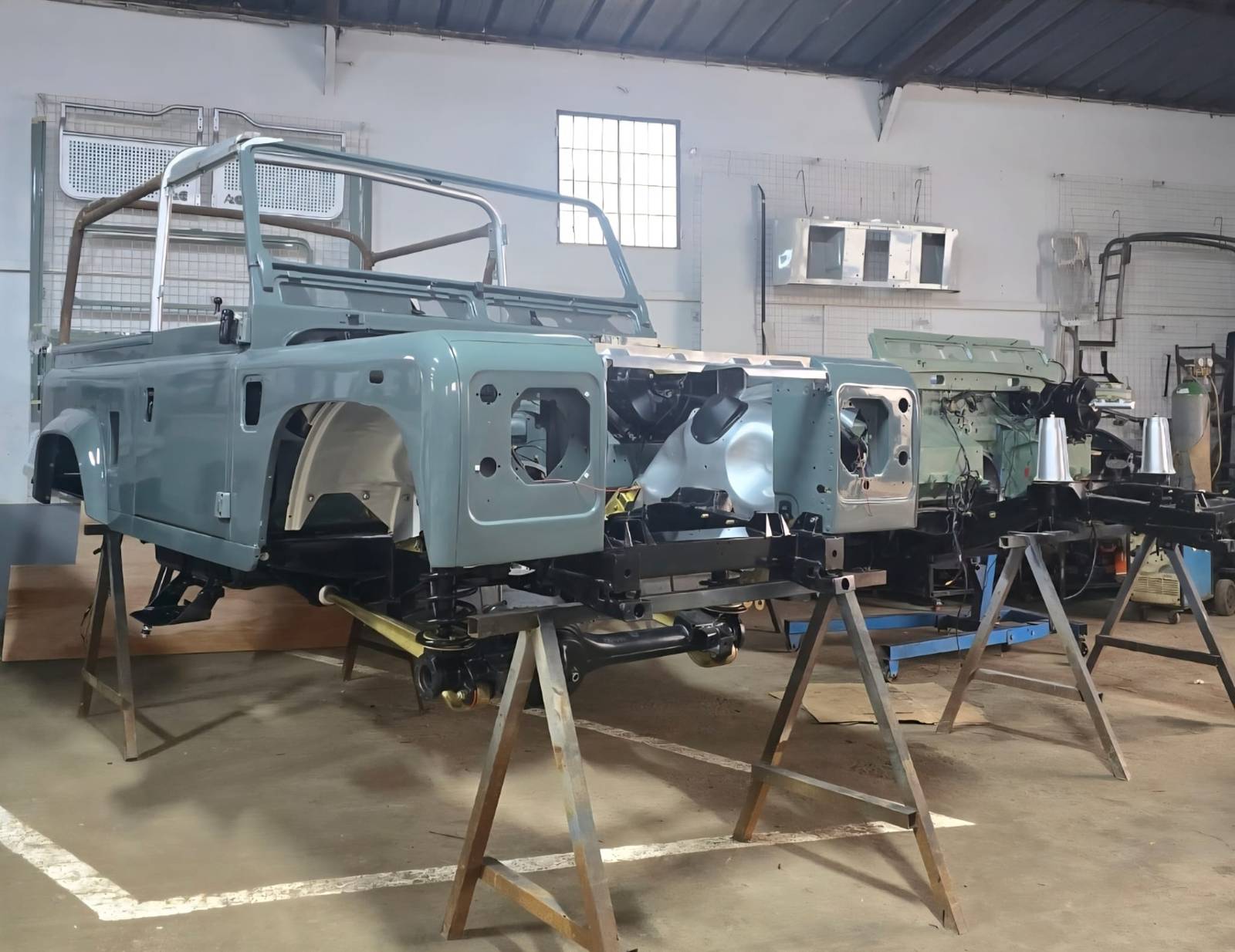 Châssis de Land Rover Defender repris à nu sur chandelles à l'atelier